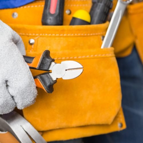 Close up of handyman in tool belt in a new house